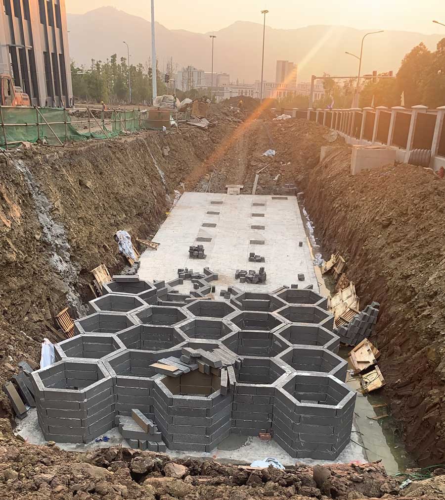 海绵城市雨水调蓄设施主体拼装现场,夕阳下深基坑内密集的硅砂蜂巢结构 海绵城市雨水调蓄设施主体拼装现场,夕阳下深基坑内密集的硅砂蜂巢结构