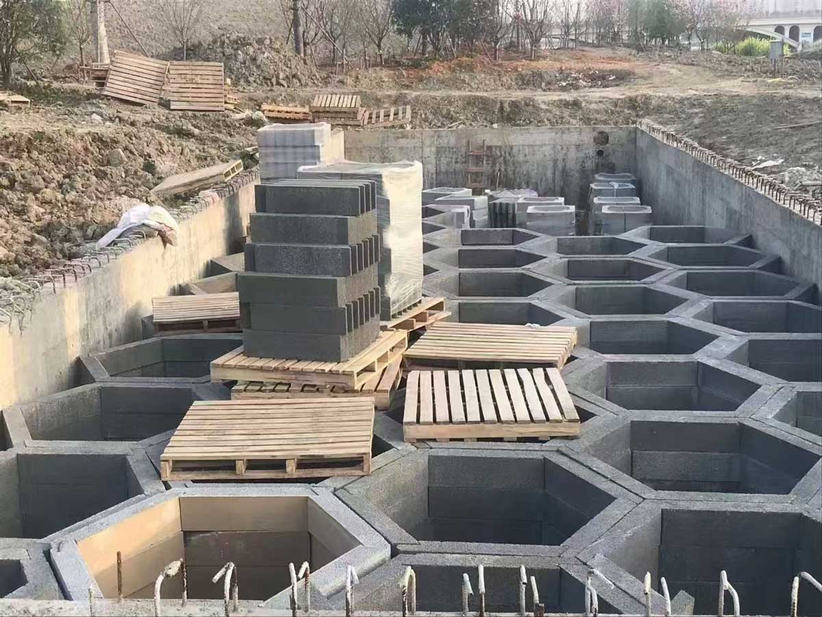 现浇混凝土基坑内，灰色硅砂雨水收集池基本铺满坑底，呈现出大面积规则的正六边形蜂巢网络空心结构。