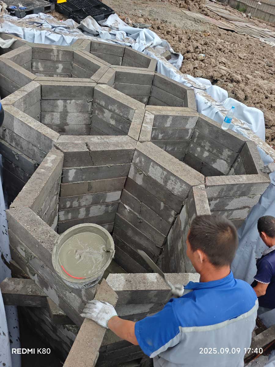 施工现场工人正在用水泥砂浆砌筑拼装蜂巢状硅砂雨水收集池模块的近景特写 施工现场工人正在用水泥砂浆砌筑拼装蜂巢状硅砂雨水收集池模块的近景特写