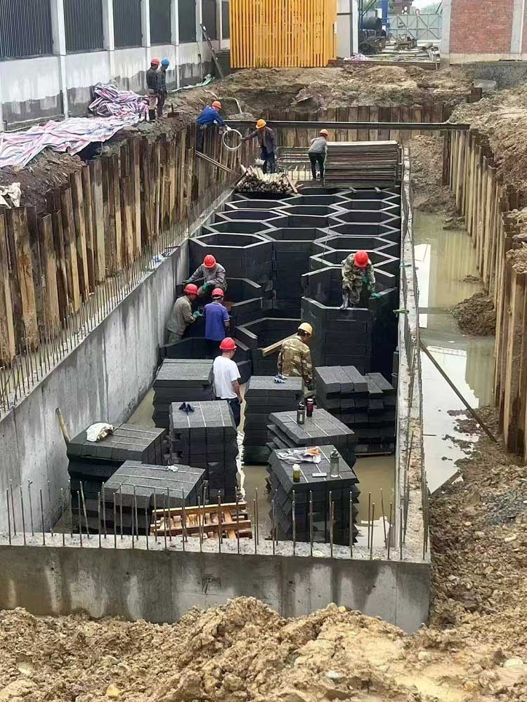 混凝土基坑内,工人们正在搬运并拼装蜂巢状地下硅砂雨水蓄水池 混凝土基坑内,工人们正在搬运并拼装蜂巢状地下硅砂雨水蓄水池