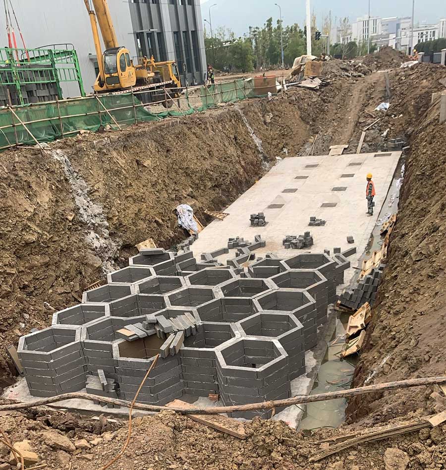 硅砂雨水收集模块安装实拍，展示蜂巢结构在深基坑内的铺设情况
