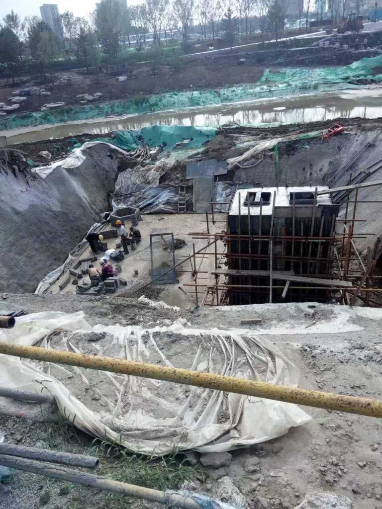 工人们正在进行地下现浇混凝土箱体脚手架搭设以及硅砂蜂巢雨水蓄水池初期底座铺设的协同施工