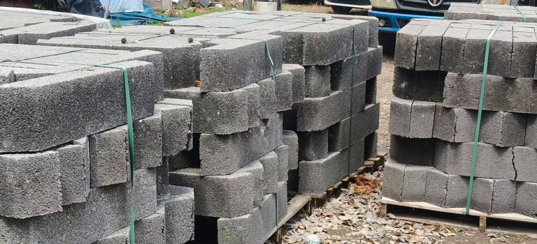 露天建材场地上灰色硅砂雨水收集池模块,近景清晰展现了砌块粗糙的多孔颗粒表面