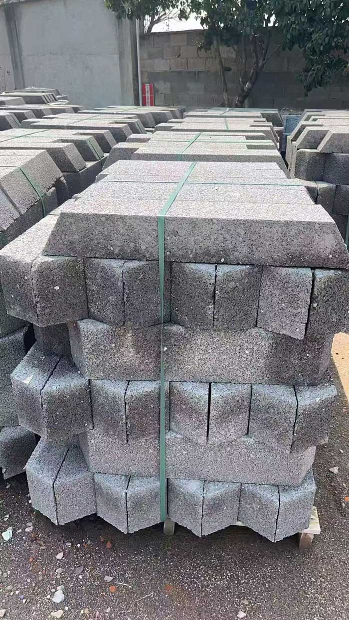 在户外的平整地面上，整齐码放着大量用于海绵城市建设的深灰色硅砂蓄水池模块